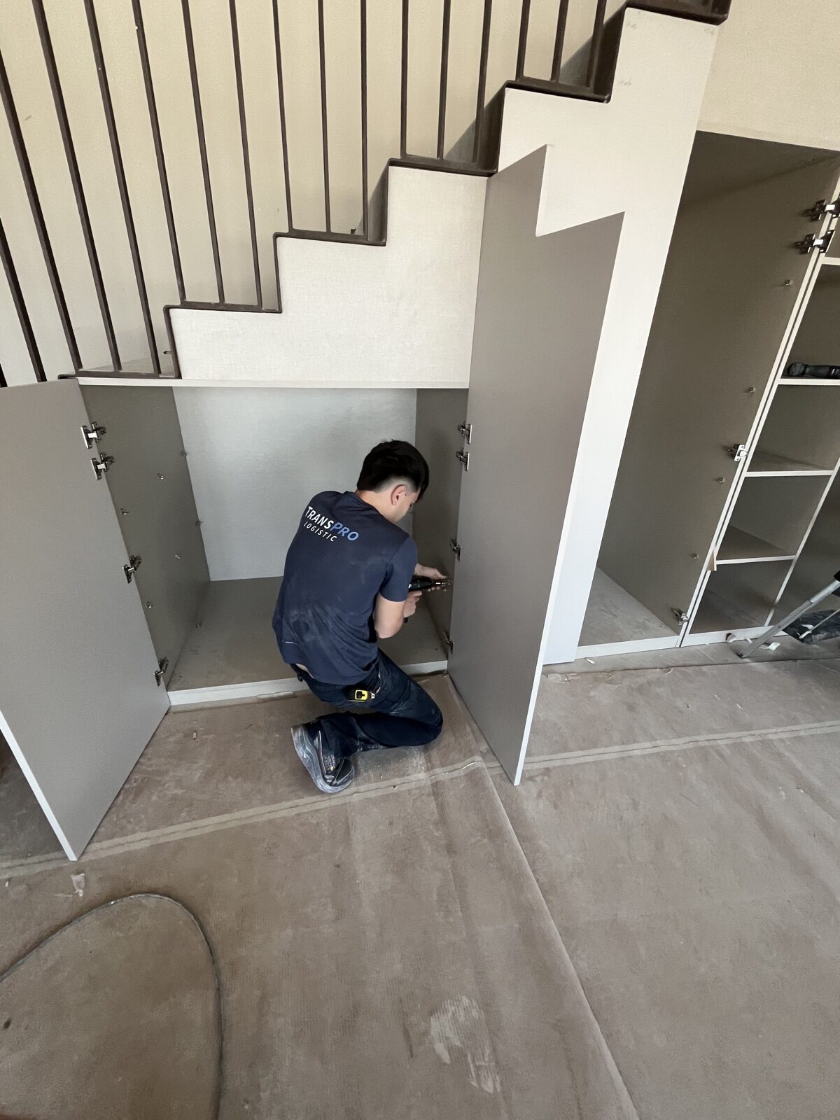 Operario de Transpro montando armarios a medida bajo el hueco de una escalera